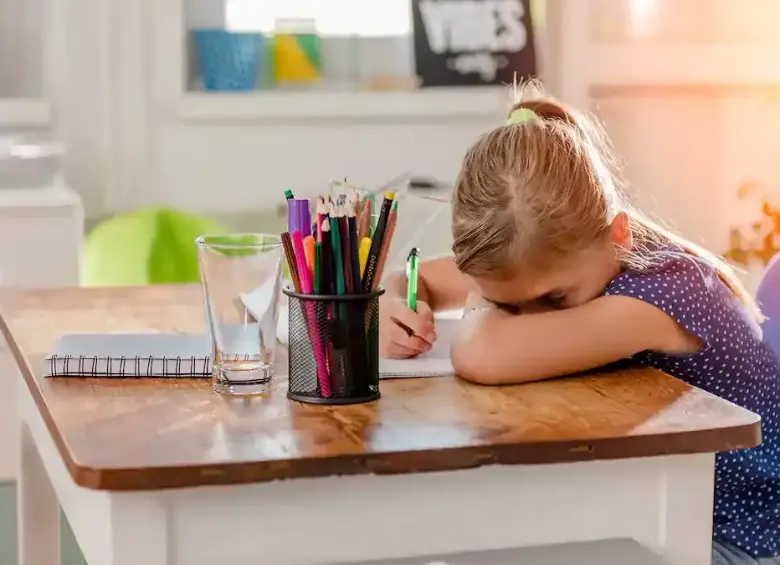 Niña recostado en un pupitre de la escuela, con malestar. FOTO: Getty