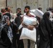 Palestinos se reúnen para recibir ayuda de alimentos en un punto de distribución de asistencia alimentaria, en la Ciudad de Gaza. FOTO: Xinhua