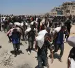 La gente camina por la calle al-Rashid, en el oeste de Jabalia, después de recibir ayuda humanitaria desde un punto de distribución de ayuda en el norte de la Franja de Gaza. FOTO: AFP