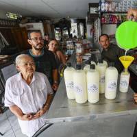 Miguel Ángel Jaramillo envasando las avenas en compañía de su padre Ómar, su abuela y su tío. Un negocio familiar que no deja de dar frutos y sigue haciendo feliz a cada cliente y visitante. FOTO Manuel Saldarriaga.