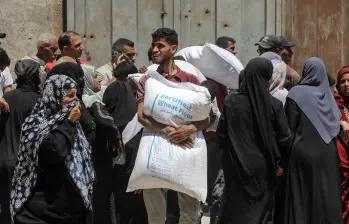 Palestinos se reúnen para recibir ayuda de alimentos en un punto de distribución de asistencia alimentaria, en la Ciudad de Gaza. FOTO: Xinhua
