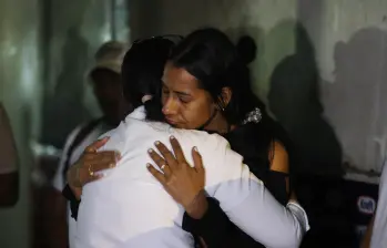 Dos mujeres reaccionan mientras participan en una oración, mientras familiares de presos esperan frente a la cárcel de El Rodeo, en Caracas, el 9 de enero de 2026 Foto: AFP