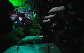 En la fotografía, ña astronauta de la NASA Christina Koch es iluminada por una pantalla dentro de la oscura nave espacial Orion en el tercer día de la misión Artemis II de la agencia. A la derecha del centro de la imagen, se observa de perfil al astronauta de la CSA (Agencia Espacial Canadiense) Jeremy Hansen, mirando por una de las ventanas de la Orion. Las luces están apagadas para evitar reflejos en las ventanas. Foto: NASA