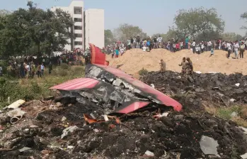 Personas observan los restos de un avión de Air India que se estrelló, en Ahmedabad, en el estado de Gujarat, India, el 12 de junio de 2025. El vuelo de Air India con destino a Londres, que llevaba 242 personas a bordo, incluidos dos pilotos y 10 miembros de la tripulación. Imagen tomada de Agencia Xinhua.