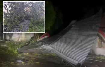 Adelante, una vía férrea de Puerto Berrío bloqueada por árboles caídos. Atrás, un techo arrancado por la fuerza del viento durante el vendaval. FOTO: Imagen tomada de redes.