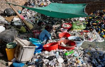 Una persona rodeada de envases de plástico. FOTO: AFP