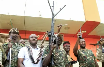Un hombre posa con soldados del ejército sudanés en Salha, al sur de Omdurman, un día después de haber recuperado la zona de manos de las fuerzas paramilitares de Apoyo Rápido (RSF), el 21 de mayo de 2025. Desde su estallido en 2023, Sudán ha sido devastado por la guerra entre las RSF y el ejército, alimentada por intereses regionales contrapuestos que incluyen a los Emiratos Árabes Unidos, Egipto, Arabia Saudita e Irán. Mercenarios extranjeros han aparecido en ambos bandos del conflicto. (Foto de Ebrahim Hamid / AFP)