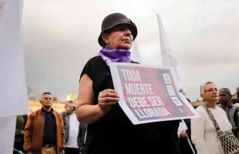 Una mujer sosteniendo una pancarta que dice “toda muerte debe ser llorada”. FOTO: COLPRENSA.