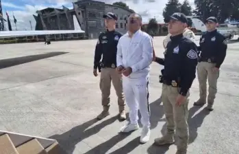 Uno de los capturados, vestido de blanco, a punto de subir al avión para su extradición. FOTO: CORTESÍA ARMADA NACIONAL
