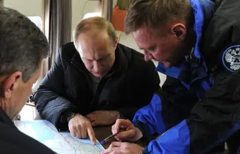  SEBASTOPOL, CRIMEA - 18 DE MARZO: El presidente ruso, Vladímir Putin (centro), el viceprimer ministro, Dmitri Kozak (izq., frente), y el director de la Agencia Federal de Carreteras de Rusia (Rosavtodor), Roman Starovoit, observan un mapa de Crimea desde un helicóptero mientras inspeccionan la zona del estrecho de Kerch. El gobierno ruso planea construir un puente que unirá la Rusia continental con Crimea. FOTO: GETTY