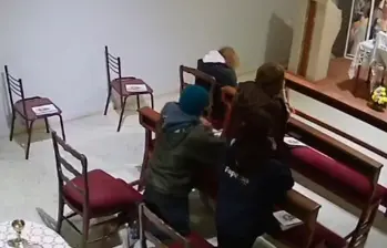 Momento en el que el hombre robó la cartera de una mujer mientras estaba arrodillado ante el altar. FOTO CAPTURA DE VIDEO