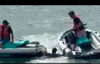Imagen del momento en el que personas en motos acuáticas sacan al hombre del agua tras saltar del buque. FOTO CAPTURA DE VIDEO