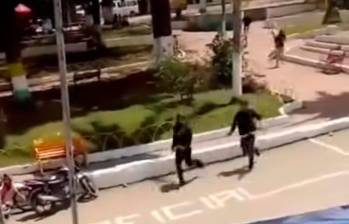 Un video aficionado captó a los sospechosos huyendo a pie por el parque principal de Morales, Cauca. IMAGEN TOMADA DE VIDEO.