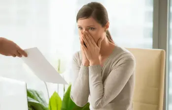 Trabajadora revisando documentos laborales tras la terminación de su contrato sin justa causa. FOTO: SHUTTERSTOCK