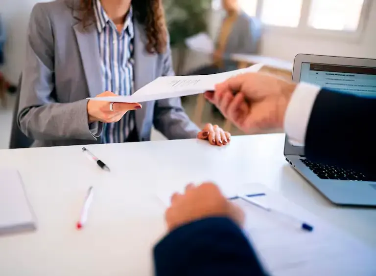 Persona en una entrevista de trabajo entregándole su hoja de vida a un reclutador. FOTO: GETTY