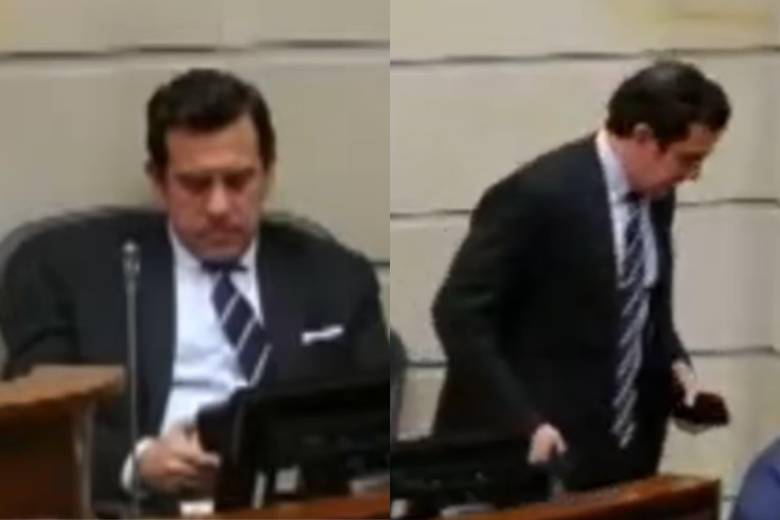El ministro del Interior Rodrigo Lara lee algo en su celular para, instantes después, retirarse de la sesión del Congreso. Foto: Captura de video.