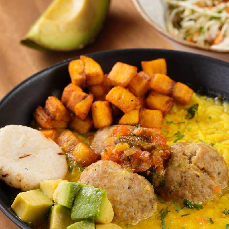 El restaurante Entrerrieles vende su propia versión de la sopa con arroz, acompañada de albóndigas, arepa, aguacate, plátano y chicharraron, 