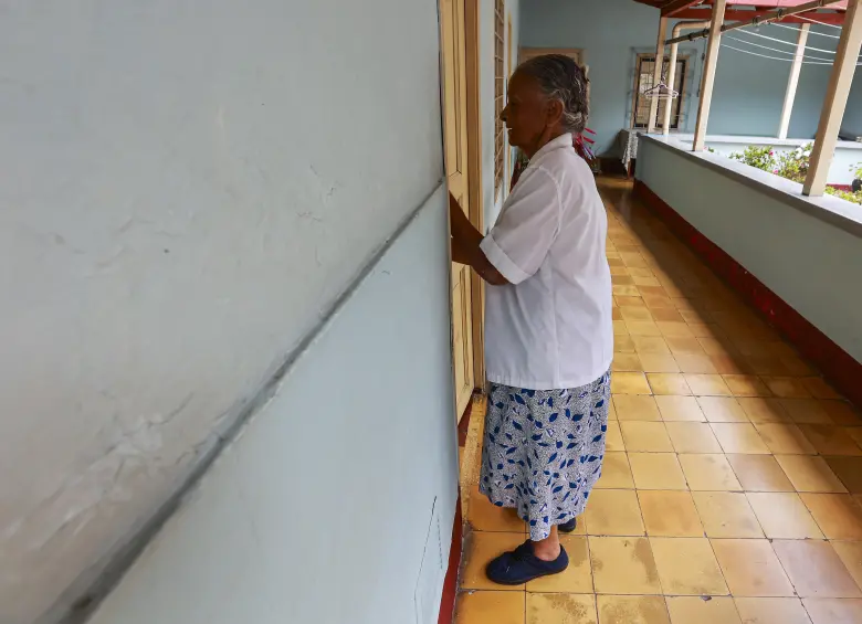 Doña Alicia ingresando a su extensa vivienda, la cual será demolida para darle cabida a la ampliación de la Avenida 34. Foto: Manuel Saldarriaga Quintero.