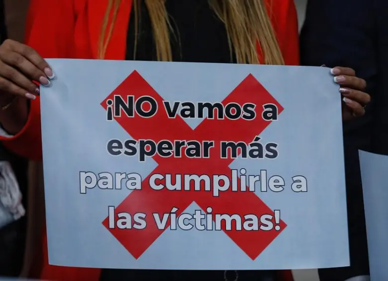Una pancarta que dice: “¡No vamos a esperar más para cumplirle a las víctimas!” FOTO: COLPRENSA