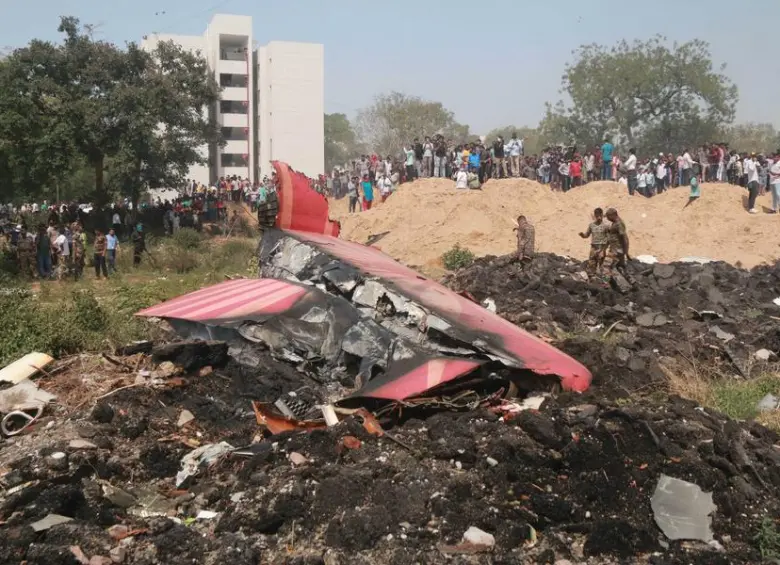 Personas observan los restos de un avión de Air India que se estrelló, en Ahmedabad, en el estado de Gujarat, India, el 12 de junio de 2025. El vuelo de Air India con destino a Londres, que llevaba 242 personas a bordo, incluidos dos pilotos y 10 miembros de la tripulación. Imagen tomada de Agencia Xinhua.
