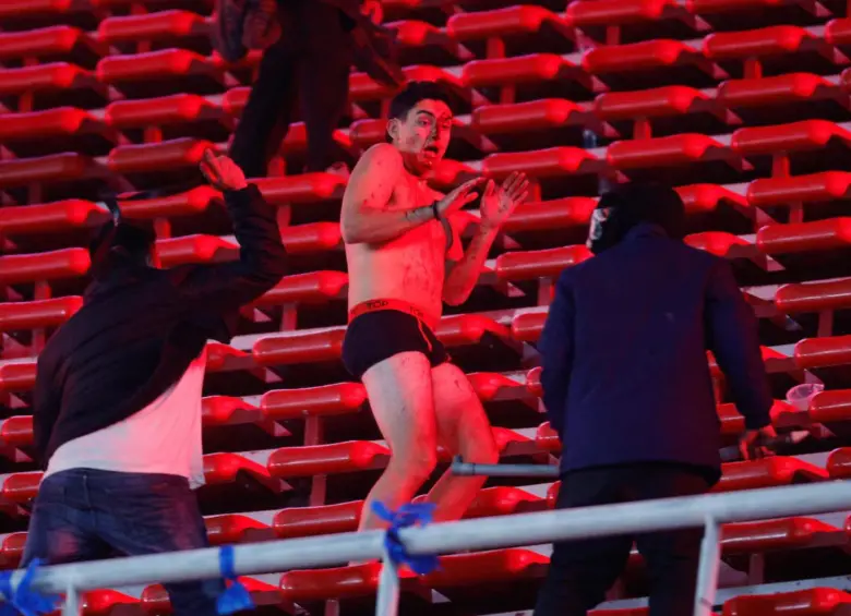 Entre varios golpeaban a los simpatizantes chilenos y los despojaban de la ropa. Foto: AFP