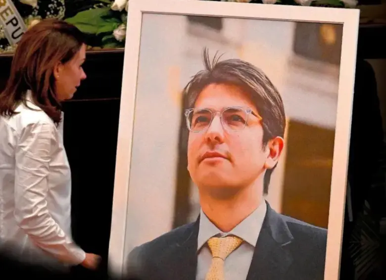 María Claudia Tarazona, mirando fijamente la foto de su esposo asesinado, Miguel Uribe Turbay. FOTO: Colprensa