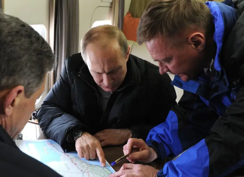  SEBASTOPOL, CRIMEA - 18 DE MARZO: El presidente ruso, Vladímir Putin (centro), el viceprimer ministro, Dmitri Kozak (izq., frente), y el director de la Agencia Federal de Carreteras de Rusia (Rosavtodor), Roman Starovoit, observan un mapa de Crimea desde un helicóptero mientras inspeccionan la zona del estrecho de Kerch. El gobierno ruso planea construir un puente que unirá la Rusia continental con Crimea. FOTO: GETTY