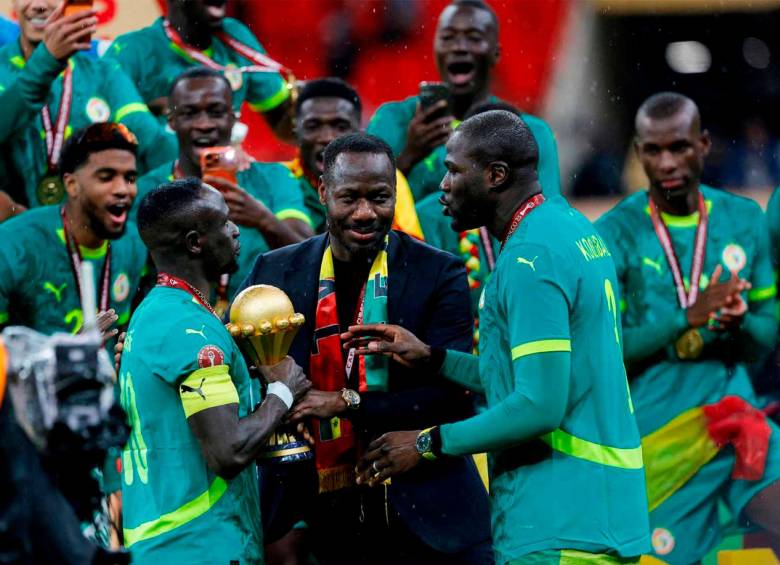 El técnico Pape Thiaw, junto a sus dirigidos y el trofeo durante la celebración del título ganado en la cancha ante Marruecos. FOTO GETTY 