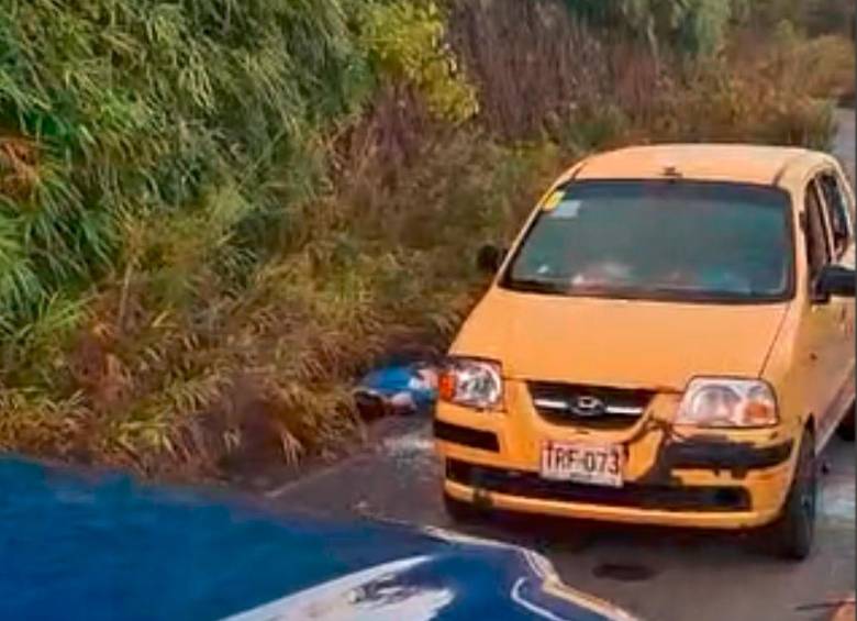 Las dos personas que iban en este taxi fueron acribilladas afuera del automotor, luego de que estructuras armadas lo interceptaran poniendo un árbol en el centro de la vía. IMAGEN TOMADA DE VIDEO.