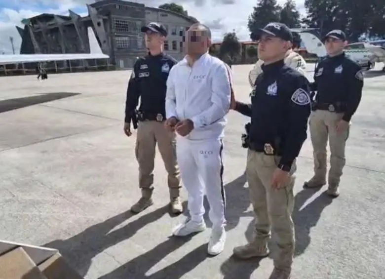 Uno de los capturados, vestido de blanco, a punto de subir al avión para su extradición. FOTO: CORTESÍA ARMADA NACIONAL