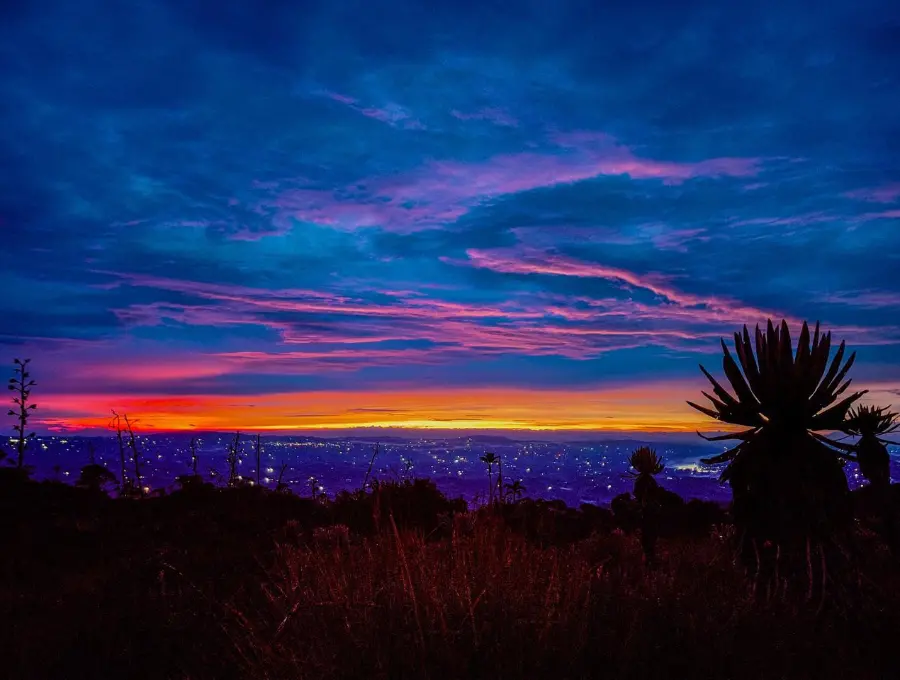 Amanecer en el Páramo de Belmira a más de 3.350 metros de altura, con el cielo teñido de tonos rojos y rosados tras una noche de caminata. Foto: Cristina Rodriguez.