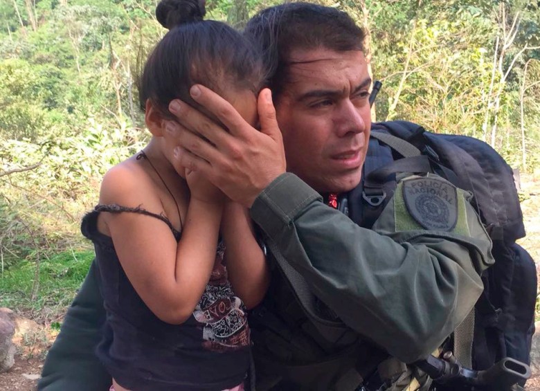 La menor es protegida por un uniformado durante el acercamiento del helicóptero en el que se hizo el rescate. FOTO POLICÍA ANTIOQUIA