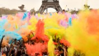 La gente arroja polvo de colores mientras celebran la finalización de sus cinco kilómetros en el Color Run 2018. Foto: CHRISTOPHE SIMON