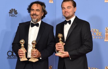 Alejandro González Iñárritu posa con Leonardo DiCaprio y los galardones para El Renacido. FOTO AP