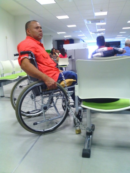 Hernan Darío Agudelo Rico de 50 años de edad perdió su paciencia de esperar la pensión por discapacidad con la empresa Colpensiones y se encadenó a una silla. FOTO CORTESÍA