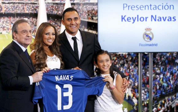 El portero costarricense Keylor Navas junto a su mujer, Andrea Salas y al presidente del club Real Madrid, Florentino Pérez (i) durante su presentación en el Estadio Santiago Bernabéu. EFE/Chema Moya