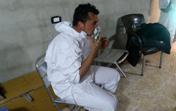 Un hombre trata de mitigar los efectos del gas que lanzaron en Siria. FOTO REUTERS
