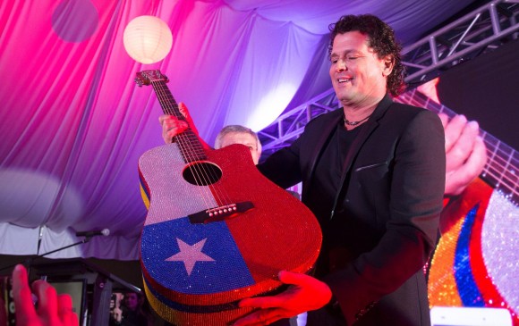 La decoración de la guitarra incluye las banderas de Chile y Colombia, además del logo de Carlos Vives atrás. FOTO afp
