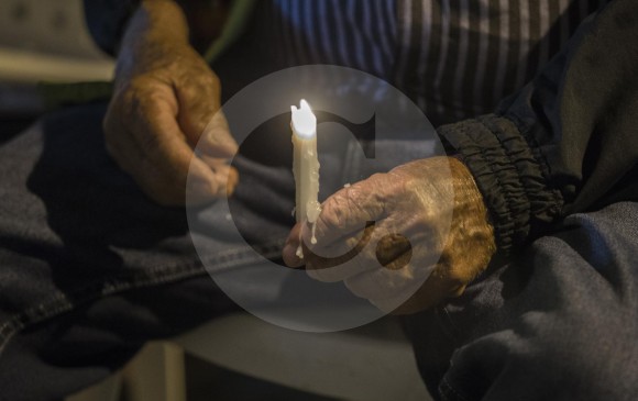 Arriba: Heriberto Giraldo García sostiene una vela durante la conmemoración de la masacre en El Topacio en el municipio de San Rafael. Evento realizado por el Centro Nacional de Memoria Histórica. Izquierda: monumento a los mineros asesinados, está ubicado en el sector de Encenillos, donde ocurrió la masacre. FOTOS donaldo zuluaga