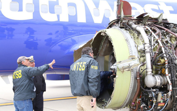 Oficiales de la Comisión Nacional de Seguridad en el Transporte trabajan para determinar las causas que generaron la explosión en la turbina del vuelo 1380 de Southwest. FOTO AFP