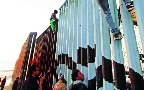 Migrantes de la primera caravana, que salió desde honduras y recorrió el territorio mexicano, comienzan a congregarse en la valla fronteriza de Tijuana en noviembre de 2018. EFE/Joebeth Terriquez