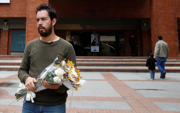 Un bogotano se acercó al centro comercial Andino a dejar flores para las víctimas. FOTO REUTERS