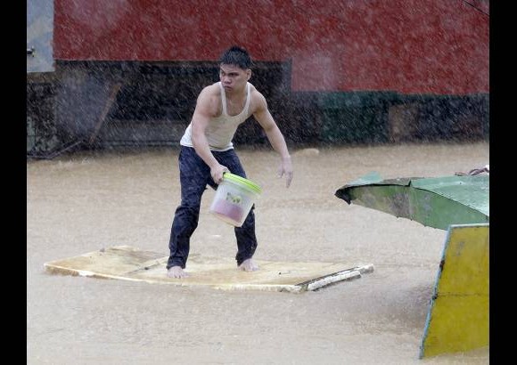 AP - Inundaciones en la ciudad de Marikina, al este de Manila, Filipinas, obligaron a sus habitantes a tratar de salir hasta flotando de la zona.