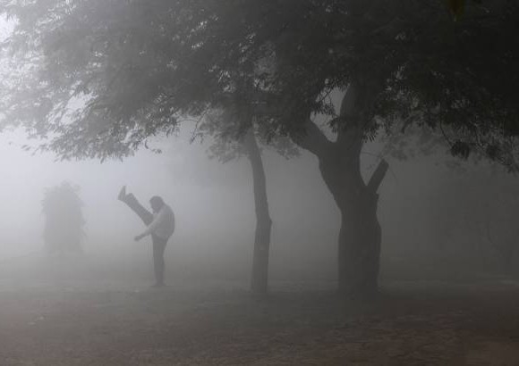 AP - A pesar de la niebla en una ma&#241;ana de esta semana en Nueva Delhi, India, un hombre realiza ejercicios de estiramiento.