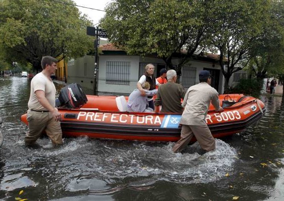Reuters - Miembros del Servicio de Guardacostas de Argentina ayudan a dos mujeres a salir de su residencia en medio de las inundaciones, despu&#233;s de las fuertes lluvias que afectaron gran parte de la ciudad de La Plata.