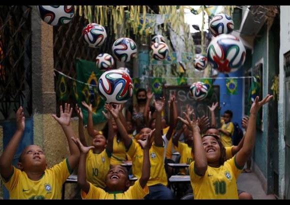 Reuters - Ni&#241;os de una escuela p&#250;blica de Brasil vestidos con la camiseta de su selecci&#243;n juegan con los balones oficiales del mundial que est&#225;n pintados con una cruz. En el pa&#237;s protestaron en las escuelas con este s&#237;mbolo para crear conciencia sobre la necesidad de que en el sistema educativo de Brasil se incluya la preparaci&#243;n para este evento.