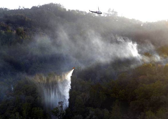 AP - Un helic&#243;ptero ayuda a controlar un incendio forestal en la regi&#243;n de Big Sur en California, Estados Unidos.