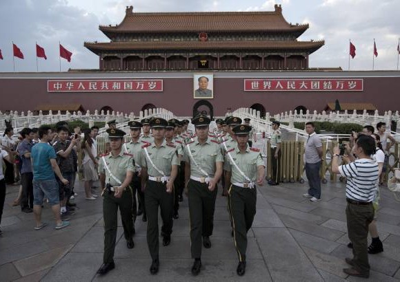AP - 28 de mayo de 2014. Marcha de Polic&#237;as chinos fotografiada por visitantes a la Puerta de Tiananmen.
