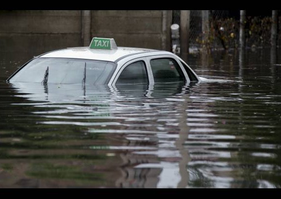 AP - Un taxi se sumerge en las aguas de la provincia de La Plata, en Argentina, las aguas inundaron las calles.
