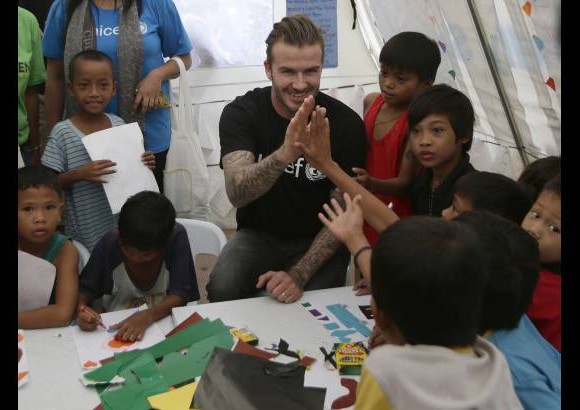 AP - David Beckham interact&#250;a con peque&#241;os sobrevivientes del tif&#243;n Haiyan durante su visita a Filipinas.